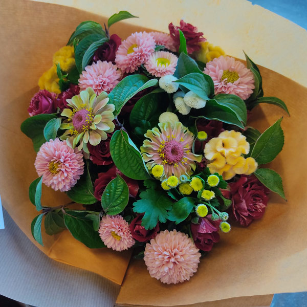 Bouquet de fleurs variées rond dans un papier kraft